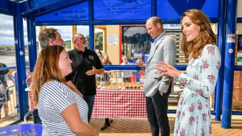 Getty Images Prince William and Catherine, chat with business owners inside Marco's cafe in Barry