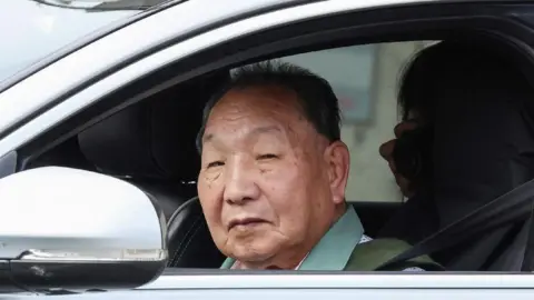 Getty Images Iwao Hakamata looks out the window of a car