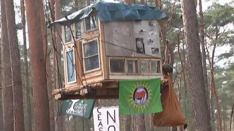 A wooden treehouse suspended from a tree