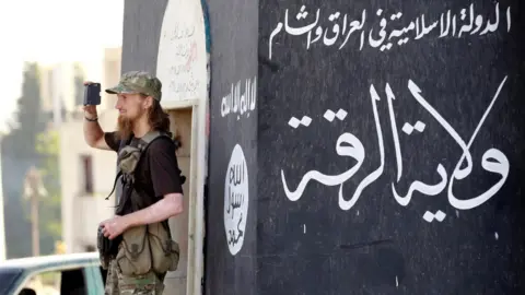 Reuters Jihadist takes a photo as IS militants celebrate in Raqqa on 30 June 2014