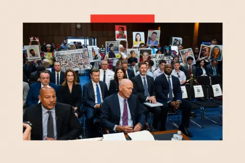 EPA People with placards sit behind then-Boeing CEO, David Calhoun