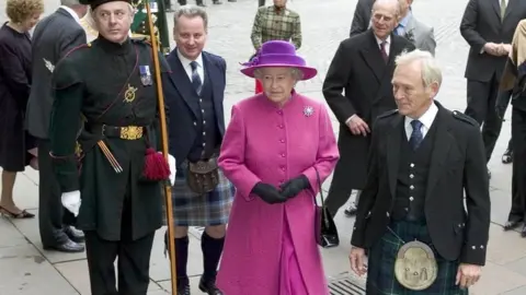 PA Queen Elizabeth arrives at Parliament Square in Edinburgh, flanked by First Minister Jack McConnell (fourth from left) and Presiding Officer George Reid (right) in October 2004