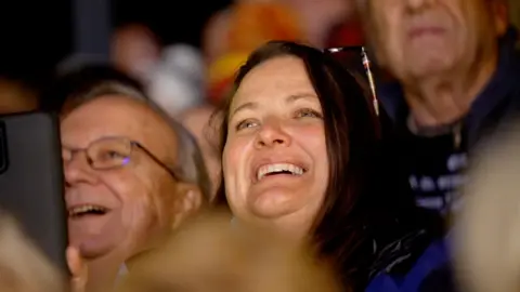 A man and a woman smile in the audience