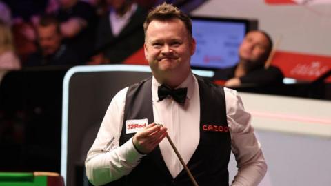 Shaun Murphy smiles as he chalks his cue