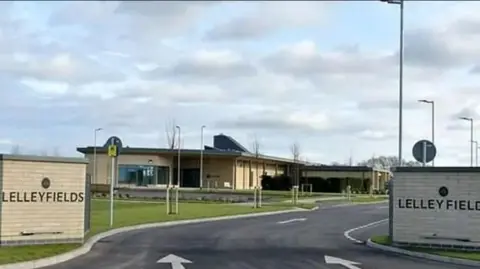 Road entrance with brick-built crematorium in background