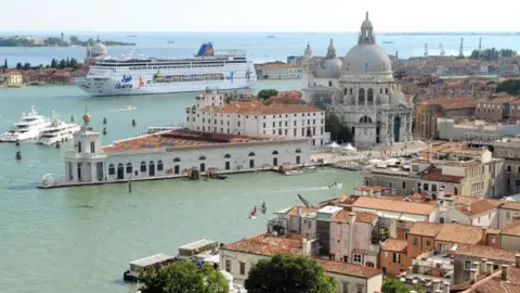 AFP A cruise ship passes through the lagoon in Venice