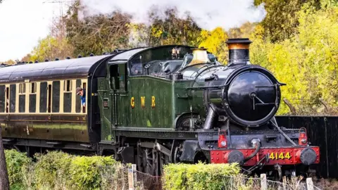 GWR locomotive Prairie 4144 - a green painted steam train, pulling a brown and cream carriage.