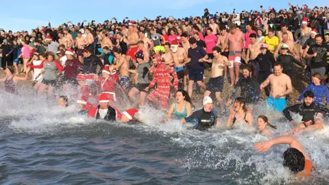 Hundreds of swimmers rushing into the sea