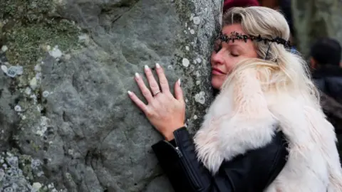 Reuters A woman wearing fur hugging the stones