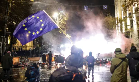 A man waves an European Union flag during a protest in front of the Parliament building in Tbilisi, Georgia