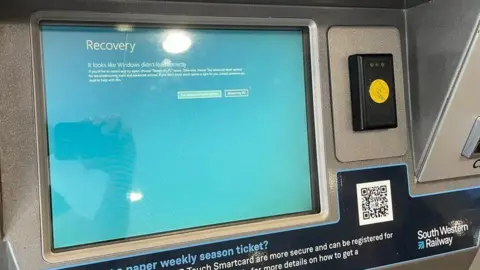 Blue screen on ticket machine with the words "it looks like Windows didn't load correctly" on it