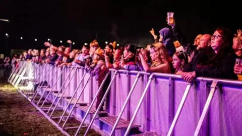 The Godney Gathering A crowd of people watching an act at a festival 