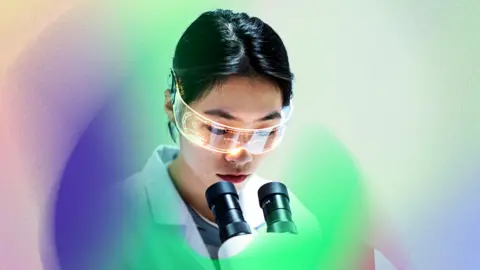 Woman looks in microscope