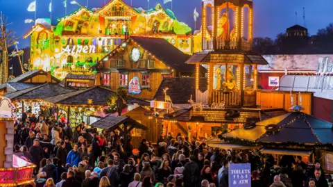 Getty Images Alpine-style bars with crowds of people standing around at Winter Wonderland