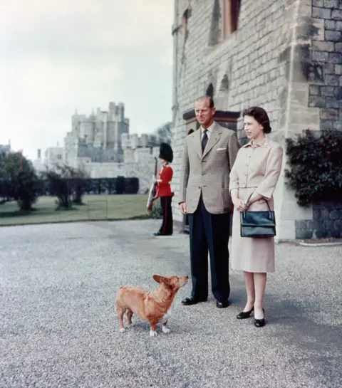 PA Media Prince Philip and the Queen with one of their dogs