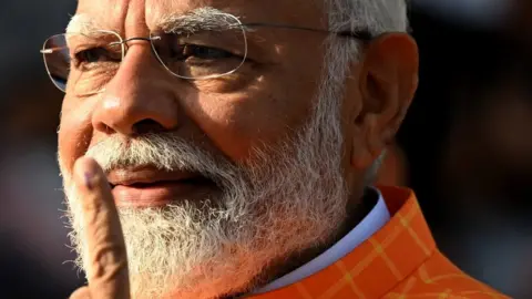 India's Prime Minister Narendra Modi, leader of the ruling Bharatiya Janata Party (BJP) displays his inked marked finger after casting his ballot at a polling booth at Ranip, Ahmedabad on May 7, 2024.