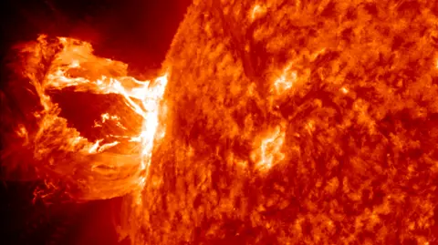 NASA Image of solar flare from Nasa's Solar Dynamics Observatory. The flare appears as vivid red and orange.