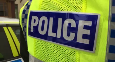 A yellow police vest with the word police.