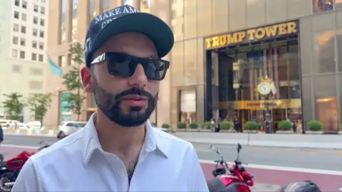 Man in cap and sunglasses outside Trump Tower in New York