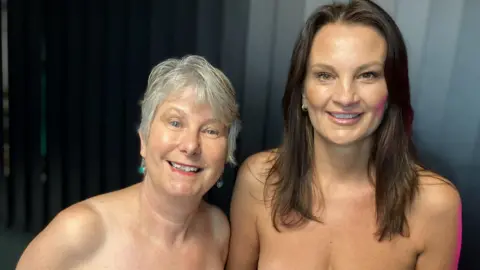 Anne, left, and Sam, Right. Margaret has short grey hair and wears turquoise drop earrings. Sam has long brown hair. Both are photographed from the chest up and are not wearing clothing. 