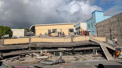 Rescue workers are seen at the site of a collapsed building after a powerful earthquake struck Port Vila, the capital city of Vanuatu, on December 17, 2024