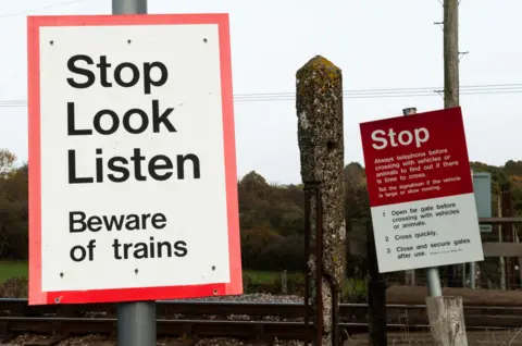 Warning signs next to a railway crossing. - stock photo