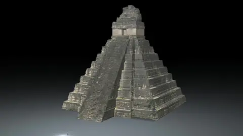 Temple seen against black background. Standing in front of it, the reporter can be seen tiny, almost invisible