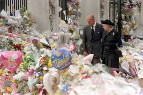 PA The Queen & Prince Philip view flowers laid to commemorate the death of the Princess of Wales