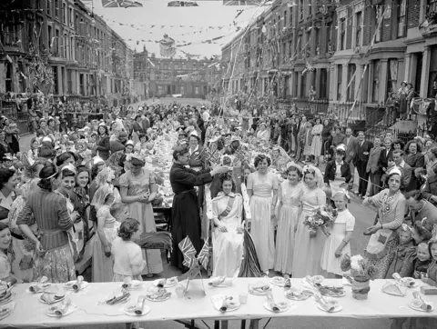 Getty Images There were many Coronation party street scenes across the UK in 1953, including this one in London, where 14 year-old Maureen Atkins was crowned Queen