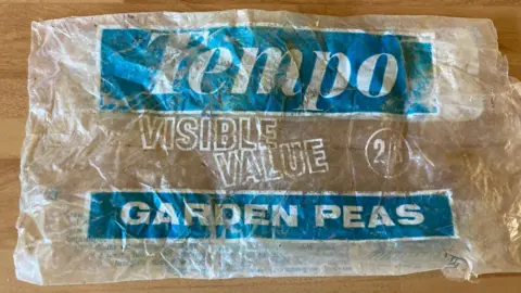 Photograph of an empty Tempo-branded bag of garden peas, with its cost showing 2/8