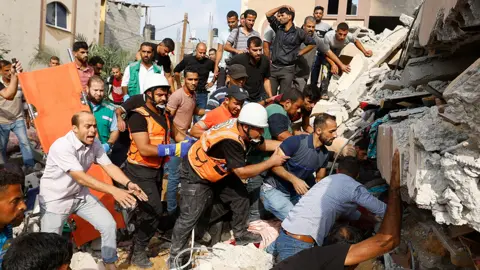 Reuters Palestinians search for casualties under the rubble of a house destroyed in Israeli strikes in Khan Younis, in the southern Gaza Strip, October 8, 2023