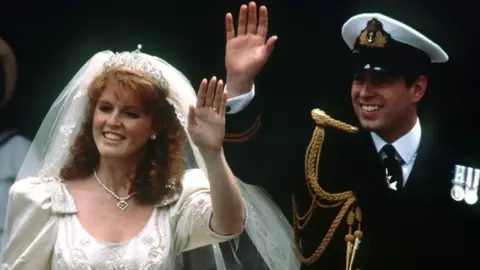 PA Media Prince Andrew and his bride Sarah Ferguson wave to crowds as they leave Westminster Abbey, London after their wedding ceremony for Buckingham Palace reception