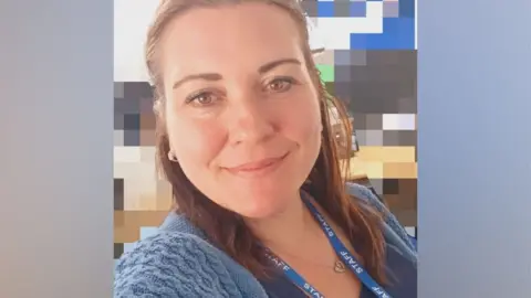 A selfie of Reneta Atanasova wearing her staff lanyard at her new work place in a school. She has long brown hair and is smiling at the camera.