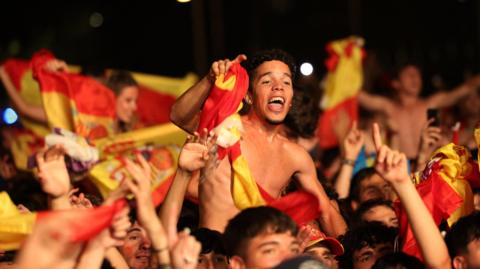 Spain fans draped in the country's flag celebrating their Euro 2024 win