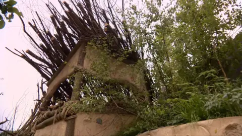 A den made from sticks and wood in a garden designed by London children