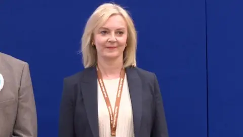 Liz Truss on stage waiting to hear the election result