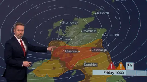 BBC Scotland weather presenter Christopher Blanchett in front of a map of Scotland showing red and amber wind warnings for the south. 