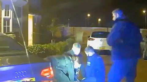 Police officers arrest dangerous driver.