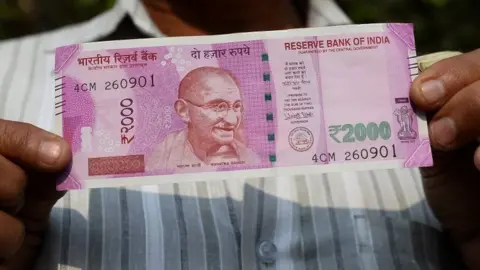 AFP An Indian man displays a new 2,000 rupee note after exchanging his old 500 and 1,000 rupee notes at a bank in New Delhi on November 10, 2016