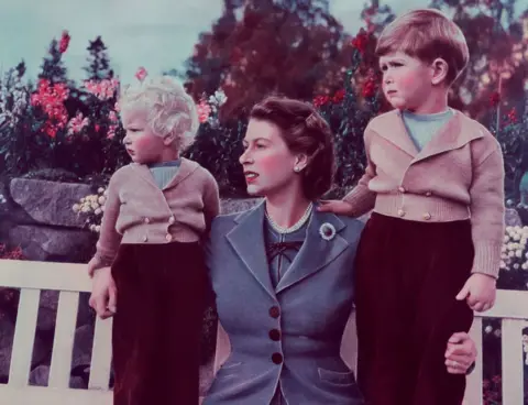 Getty Images Queen Elizabeth with her children Charles and Anne at Balmoral in 1952