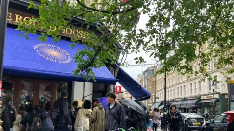 Oliver Milburn People peered through a pub's windows in central London to watch the Coronation