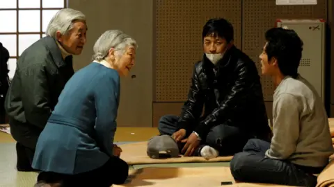 Reuters Japan's Emperor Akihito and Empress Michiko talk with evacuees from the March 11 earthquake and tsunami at Tokyo Budoh-kan