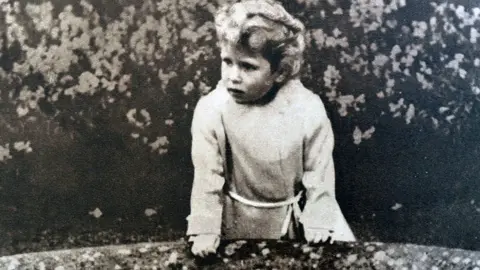 Getty Images A Young Princess Elizabeth, later Queen Elizabeth II stands on a bridge in the Glamis Castle in Scotland, where both princesses grew up.