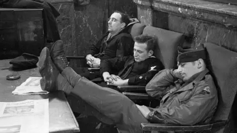 Getty Images A photo taken on 27 January 1945 of American GIs catching up on their sleep inside Rainbow Corner, the American Red Cross club for servicemen in London's Piccadilly