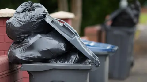 PA Black bags bulging out of a bin