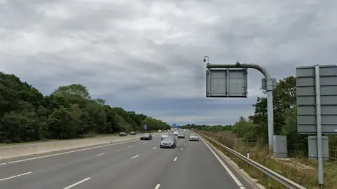 A Google street view screenshot of a motorway with trees on either side.