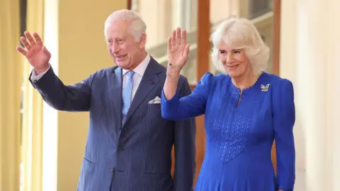 King Charles and Queen Camilla waving