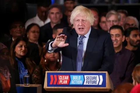 Reuters Boris Johnson behind a pulpit addressing a crowd of Conservative supporters in central London