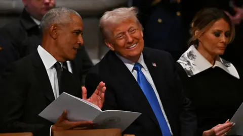 Barack Obama and Donald Trump chat as they await the funeral service to begin for former US President Jimmy Carter.