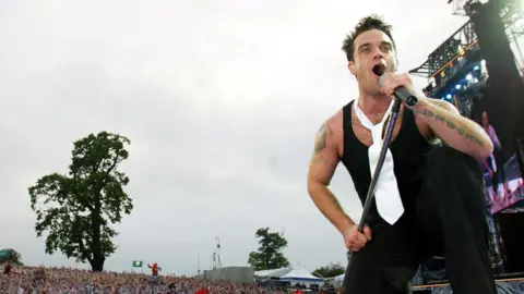 Robbie Williams on stage at Knebworth